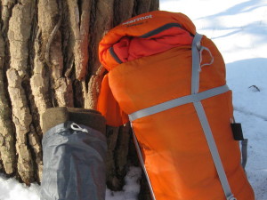 Orange synthetic winter sleeping bag with surplus heavy wool blanket.